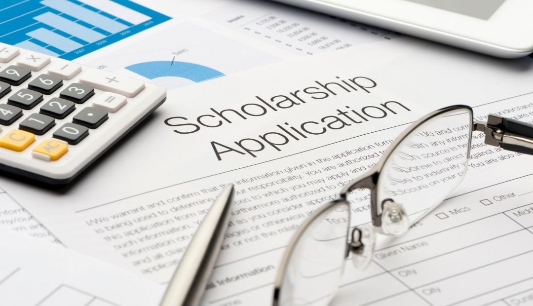 Scholarship application on desk with glasses and pens